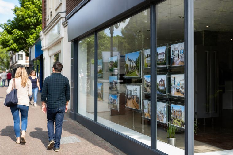 Estate agency window display with lit property listings