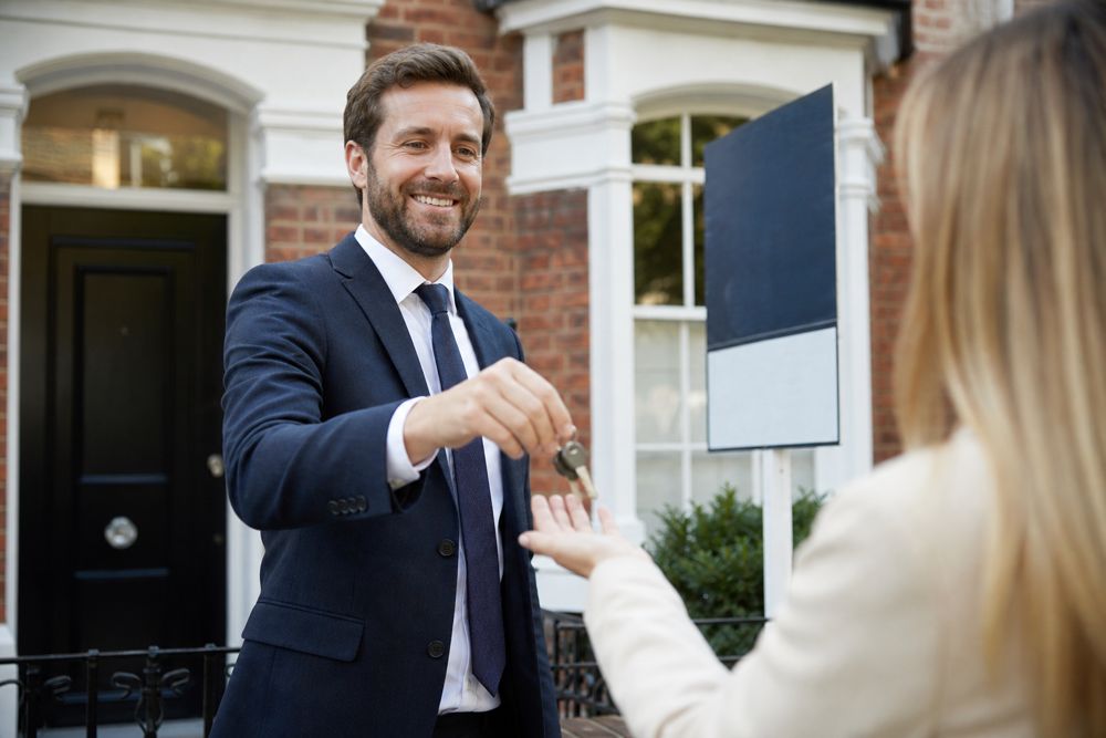 Estate agent handing house keys to a new owner